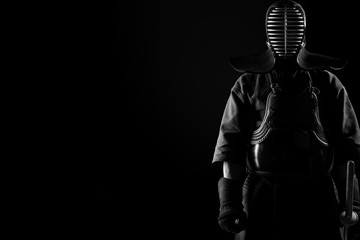 Fototapeta na wymiar Male in tradition kendo armor with Samurai sword katana. shot in studio. Isolated on black background