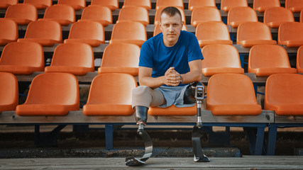 Athletic Disabled Fit Man with Prosthetic Running Blades is Preparing for a Training on an Outdoor...