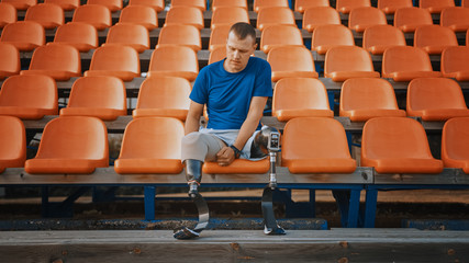 Athletic Disabled Fit Man with Prosthetic Running Blades is Preparing for a Training on an Outdoor...