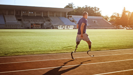 Athletic Disabled Fit Man with Prosthetic Running Blades is Training on an Outdoors Stadium on a Sunny Afternoon. Amputee Runner Jogging on a Stadium Track. Motivational Sports Shot.