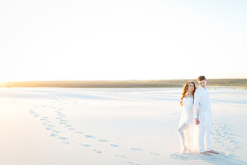 Fototapeta na wymiar Newlyweds on a white desert island