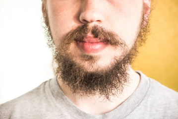 Young man with a shaggy beard and mustache. Before going to the barbershop.