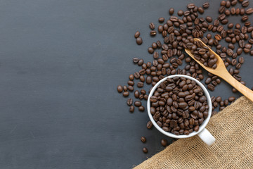 cup of coffee and bean on black wooden table background. top view