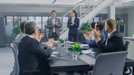In the Corporate Office Meeting Room: Two Young and Ambitions Start-up Creators Give a Speech to a Group of Venture Capital Investors, Businesspeople Cheer and Applaud in Successful Agreement