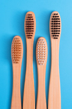 Bamboo toothbrushes on blue background. Eco friendly daily oral hygiene, teeth care and health. Cleaning products for mouth. Dental care concept
