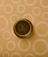 Black coffee with cream in a transparent cup in the middle of a brown background like cream with sharp white circles