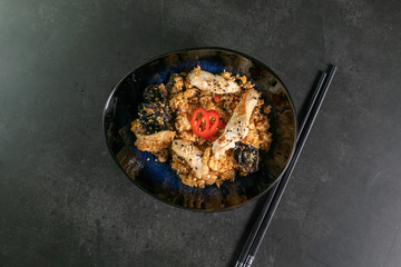 beef tahan fried Japanese rice with vegetables and slices of beef in a black plate