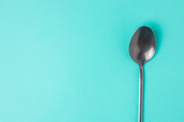 Teaspoon on a blue background with copyspace. Top view.