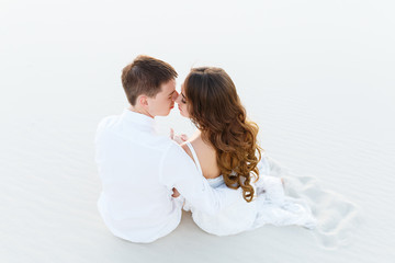 groom hugging bride in the desert at sunset