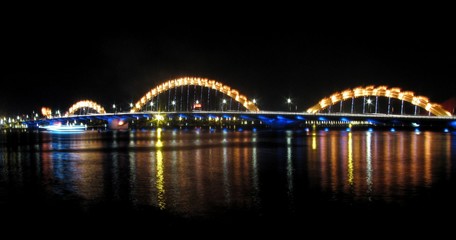 Fototapeta na wymiar Bridge Over River At Night