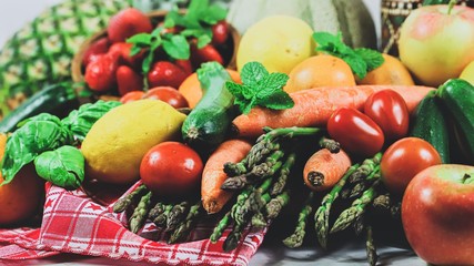full frame of a rustic composition of fruit and vegetables arranged on a table
