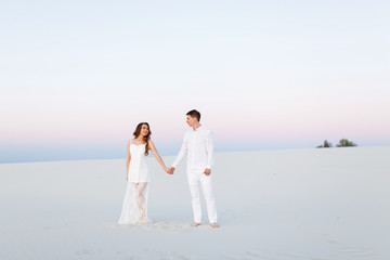 Fototapeta na wymiar Newlyweds on a white desert island