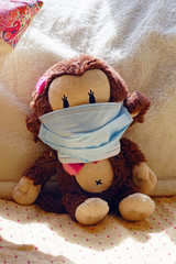 A childrens plush stuffed animal toy wearing a face mask during the COVID-19 pandemic