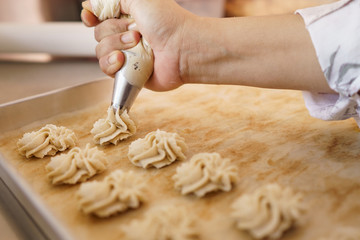 semprit cake. asian bite sized dessert. piping some dough kue sepirit