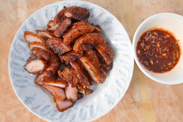 traditional Thai culture fried pork cuisine style or moo tod one of the most favorite famous street fast foods menu at thailand homemade
with hot spicy sauces on table wood dish sticky rice vegetable
