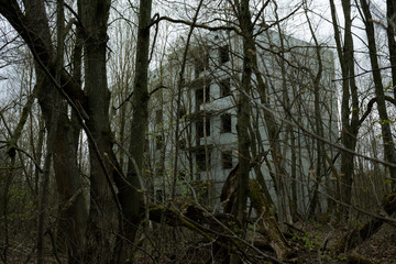 An old abandoned unfinished building of the USSR, in the forest on a cloudy day, atmospheric abandonment