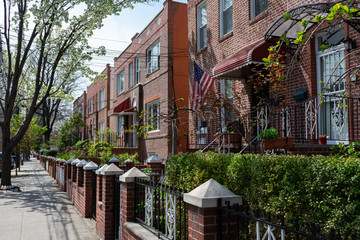 Beautiful Row of Old Homes along a Sidewalk during Spring in Astoria Queens New York