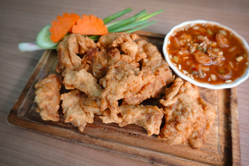 traditional Thai culture fried pork cuisine style or moo tod one of the most favorite famous street fast foods menu at thailand homemade
with hot spicy sauces on table wood dish sticky rice vegetable