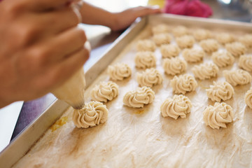 semprit cake. asian bite sized dessert. piping some dough kue sepirit