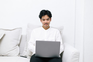 Attractive asian male working with computer laptop at home. Analyzing online data to success business