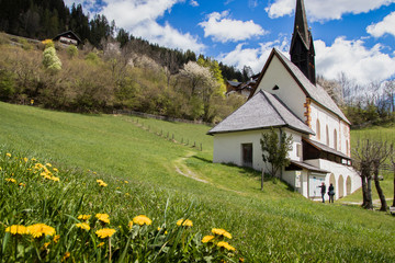 Die  Kirche von St. Kathrein in Bad Kleinkirchheim/K&auml;rnten inmitten einer Fr&uuml;hlingswiese