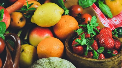 
fruits and vegetables with a bowl with strawberries in the foreground