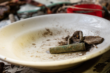 An old plate with leaves and a sleeve inside an abandoned house
