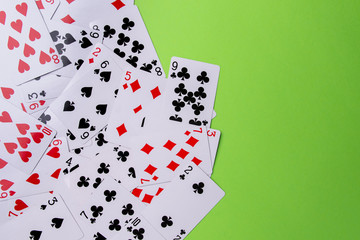 Playing cards on a green background. From above. Place for text