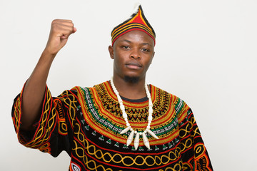 Obraz premium Young handsome African man in traditional clothing with fist raised