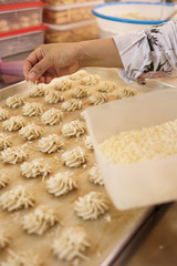 hand put a cheese topping on a cake. semprit traditional cake. kue semperit