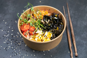 Hawaiian salmon fish poke bowl with rice, radish,cucumber, tomato, sesame seeds and seaweeds. Buddha bowl. Diet food