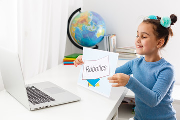 little girl studying robotics on laptop online