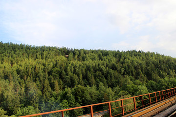 Small house in a mountain forest, photo from the railway bridge.