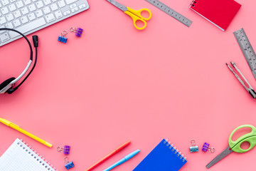 Education Online School Concept. Stationery on pink office desk top view frame copy space