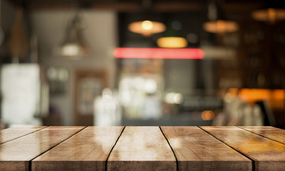 Empty old wood table top with bokeh coffee shop interior background.