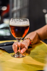 holding a glass of red beer