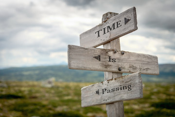 time is passing text engraved on old wooden signpost outdoors in nature. Quotes, words and...