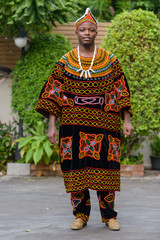 Full body shot of young African man wearing traditional clothing outdoors