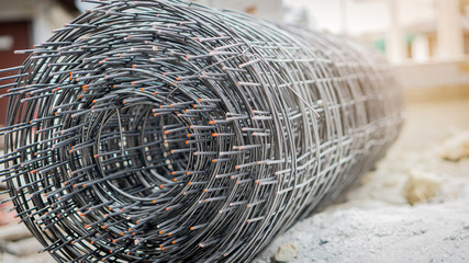 Rolled steel mesh laid on the floor for construction and light orange color with a side view.