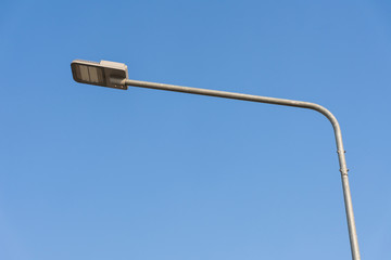 Street light LED on steel pole with clear blue sky.