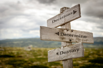 decisions determine destiny text engraved on old wooden signpost outdoors in nature. Quotes, words and illustration concept.