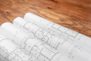 House construction plans spread out on a wooden table