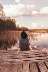 rear view of a young girl sitting on a pier