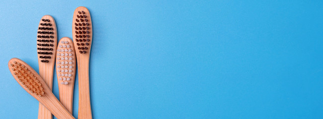 Bamboo toothbrushes on blue background. Eco friendly daily oral hygiene, teeth care and health. Cleaning products for mouth. Dental care concept. Empty place for text or logo.