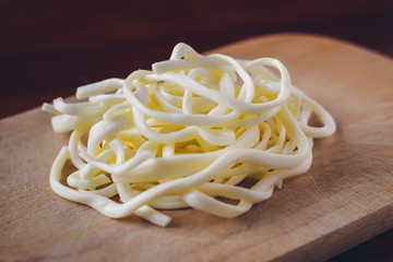Soft cheese Chechil on plate on wooden table