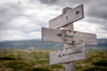 i am available text engraved on old wooden signpost outdoors in nature. Quotes, words and illustration concept.
