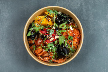 Hawaiian salmon fish poke bowl with rice, radish,cucumber, tomato, sesame seeds and seaweeds. Buddha bowl. Diet food