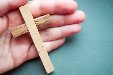 Hand holds wooden cross, easter day, world prayer day, international prayer day	

