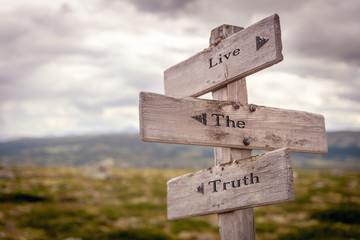 live the truth text engraved on old wooden signpost outdoors in nature. Quotes, words and...