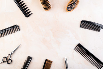 Hairdressing equipment. Combs, scissors on beige desk top-down frame space for text